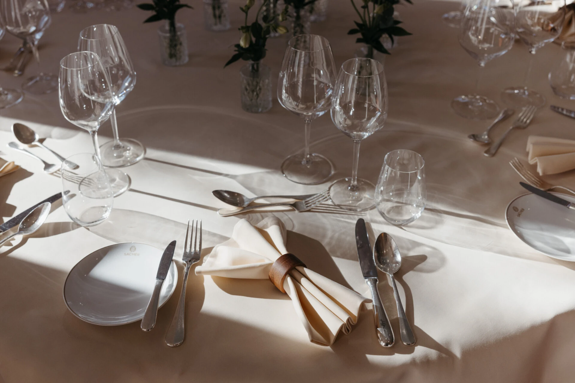 Fine dining table setting at Hotel Sacher Salzburg with wine glasses, folded napkins, silver cutlery and elegant table decor for private events.