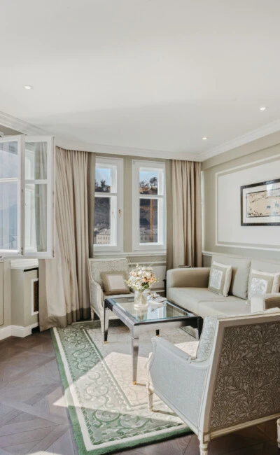 Living area of the Signature Suite with View at Hotel Sacher Salzburg, featuring an elegant seating area, large windows and views of Salzburg