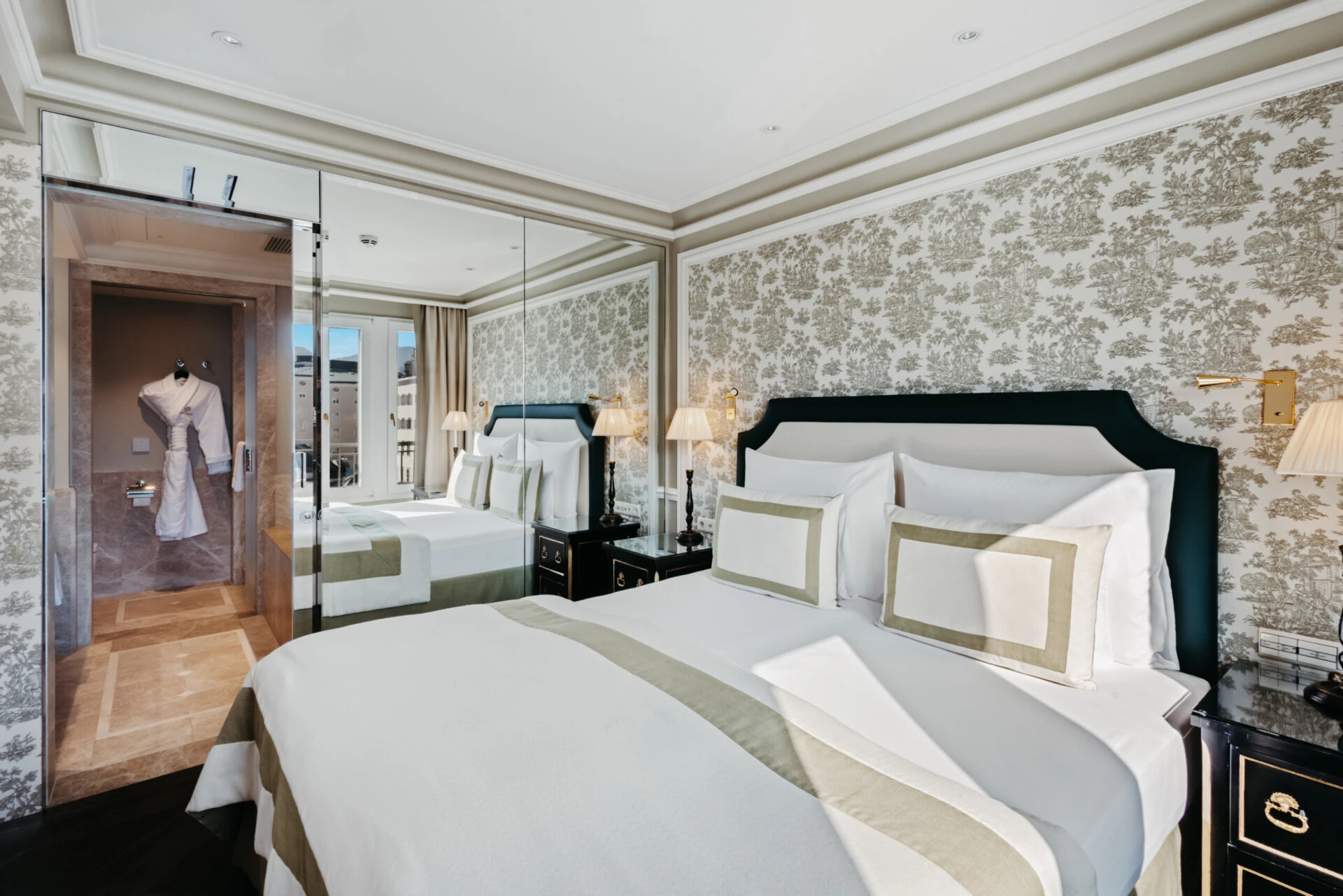 Bedroom of the Signature Suite with View at Hotel Sacher Salzburg, featuring classic interiors, a large mirror and adjoining marble bathroom