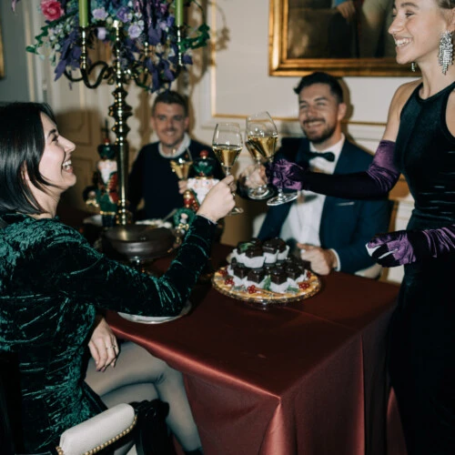 Elegantly dressed guests raise a champagne toast during a festive celebration at Hotel Sacher Wien.