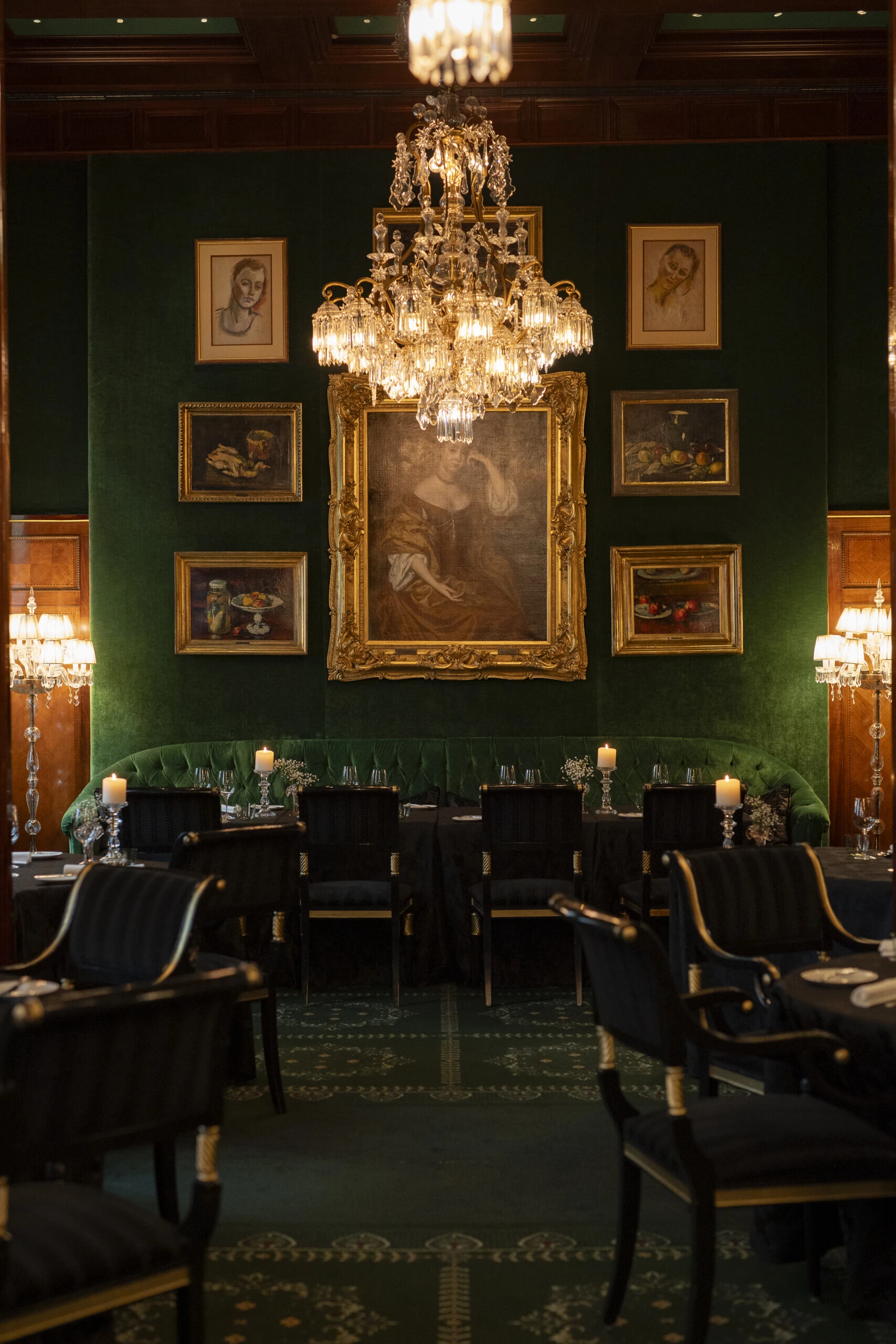 Stylish interior of the Restaurant Grüne Bar with green velvet walls, candlelight and classic furnishings.