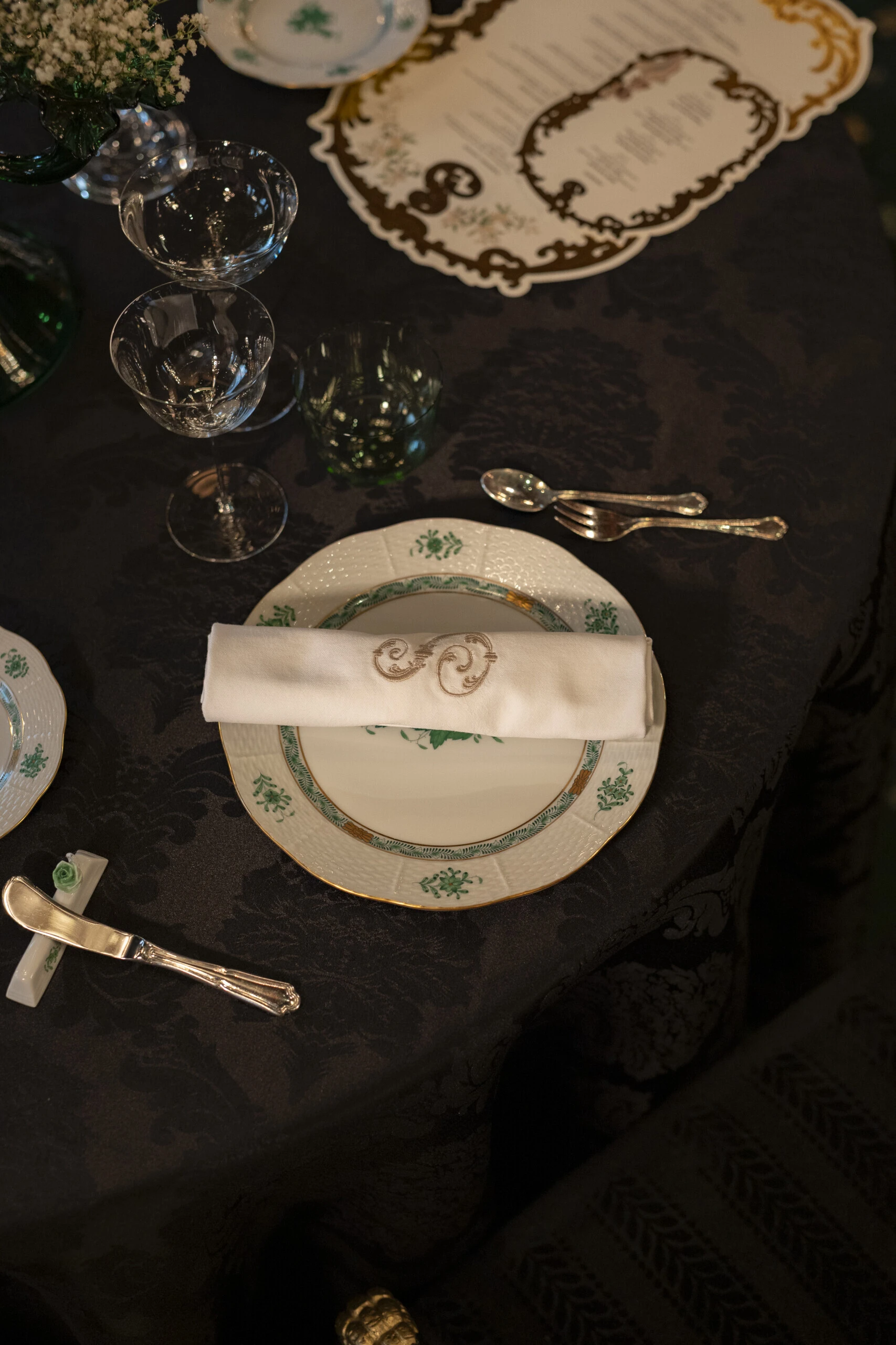 Elegantly set table with historic porcelain and an embroidered napkin in the Restaurant Grüne Bar.