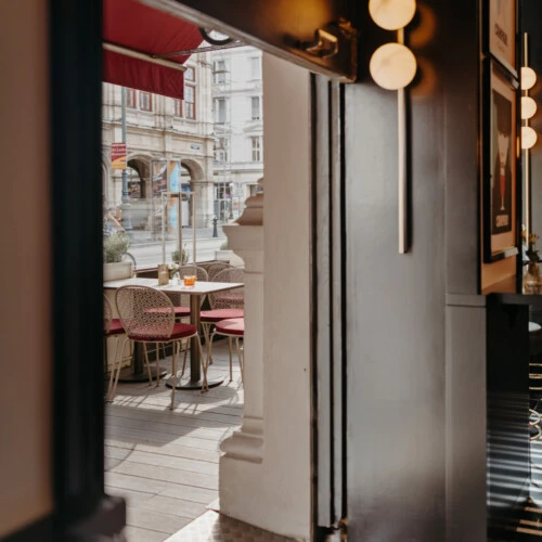 View from Salon Sacher onto the adjoining terrace with outdoor seating.