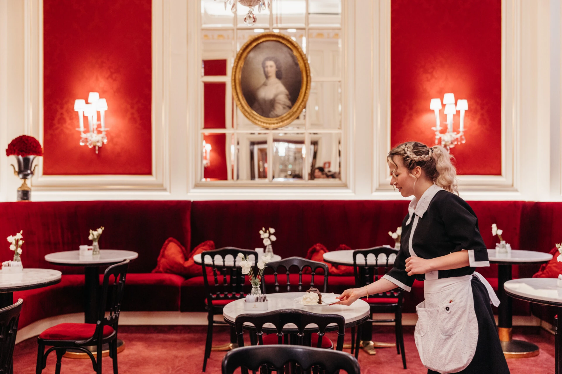 Staff member serving a slice of Original Sacher-Torte at Café Sacher Vienna.