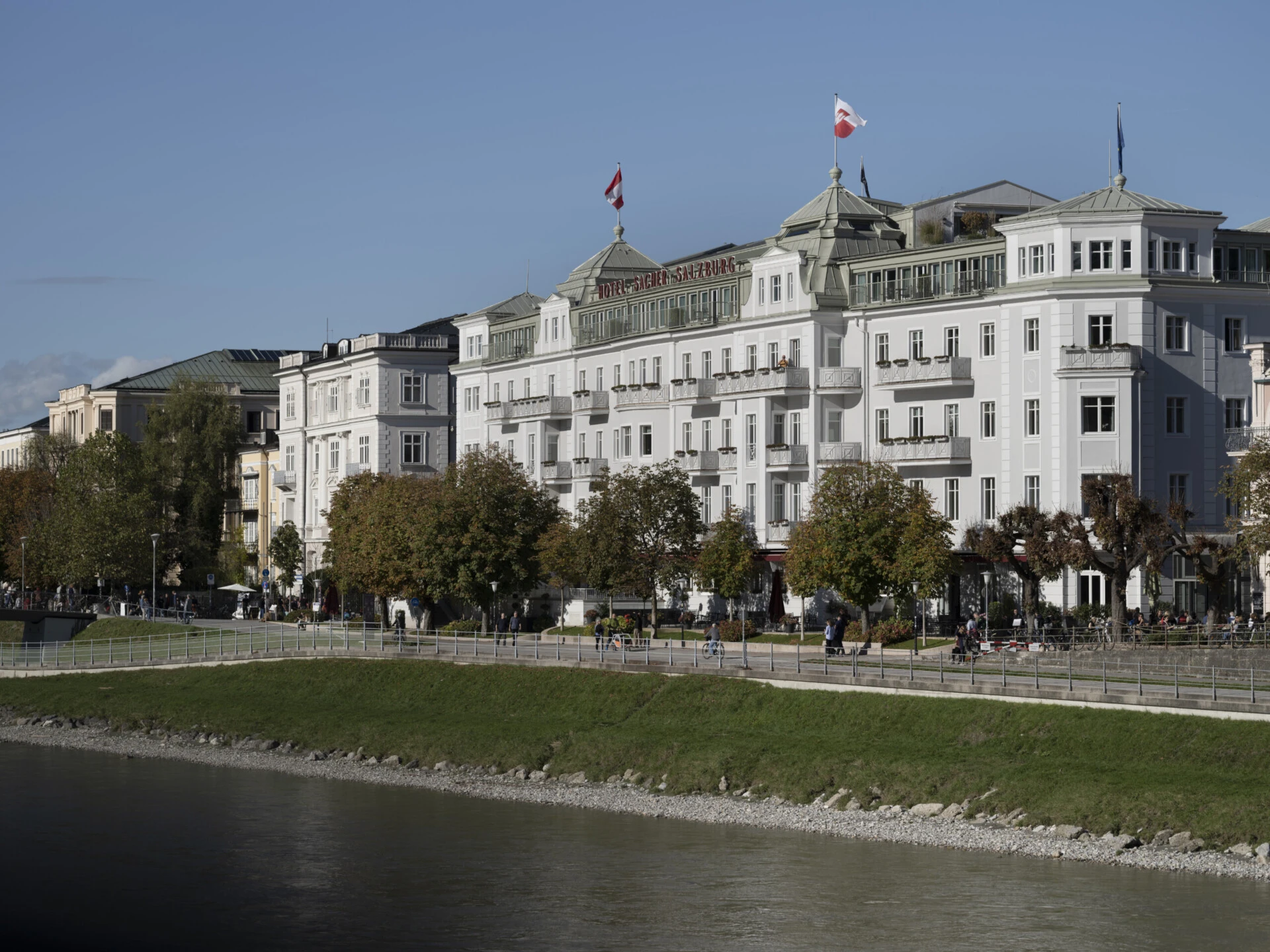 Exterior view of Hotel Sacher Salzburg along the Salzach River.