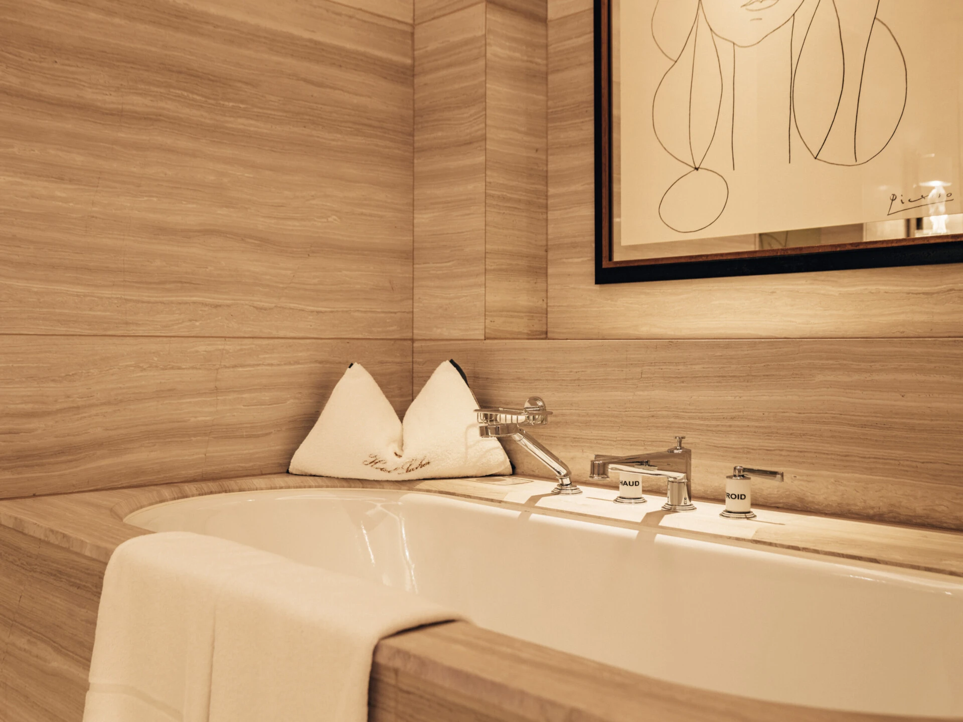 Elegant bathroom in the Sky Suite with a marble bathtub and modern art.