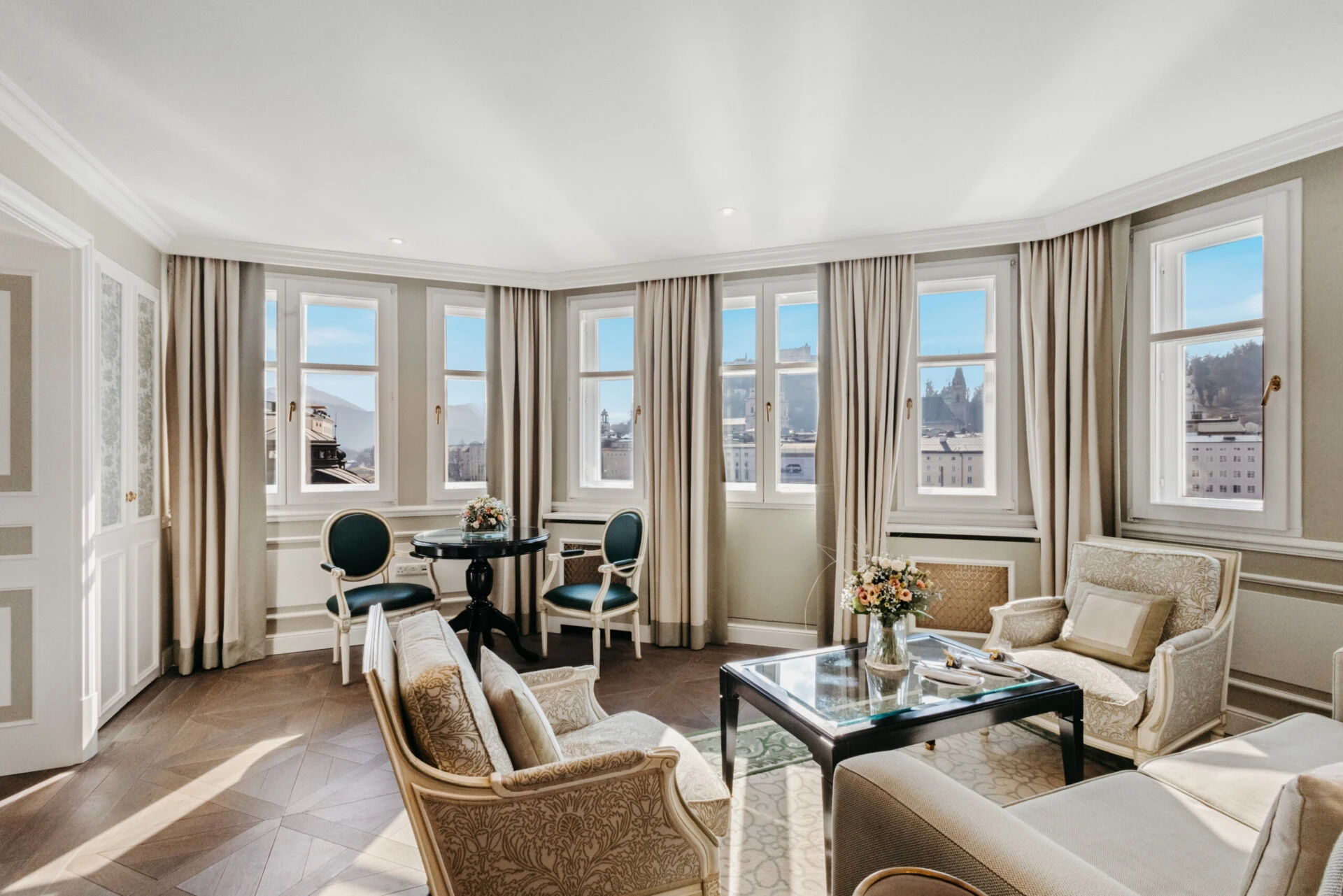 Bright signature suite at Hotel Sacher Salzburg with a living area, bedroom and city views.