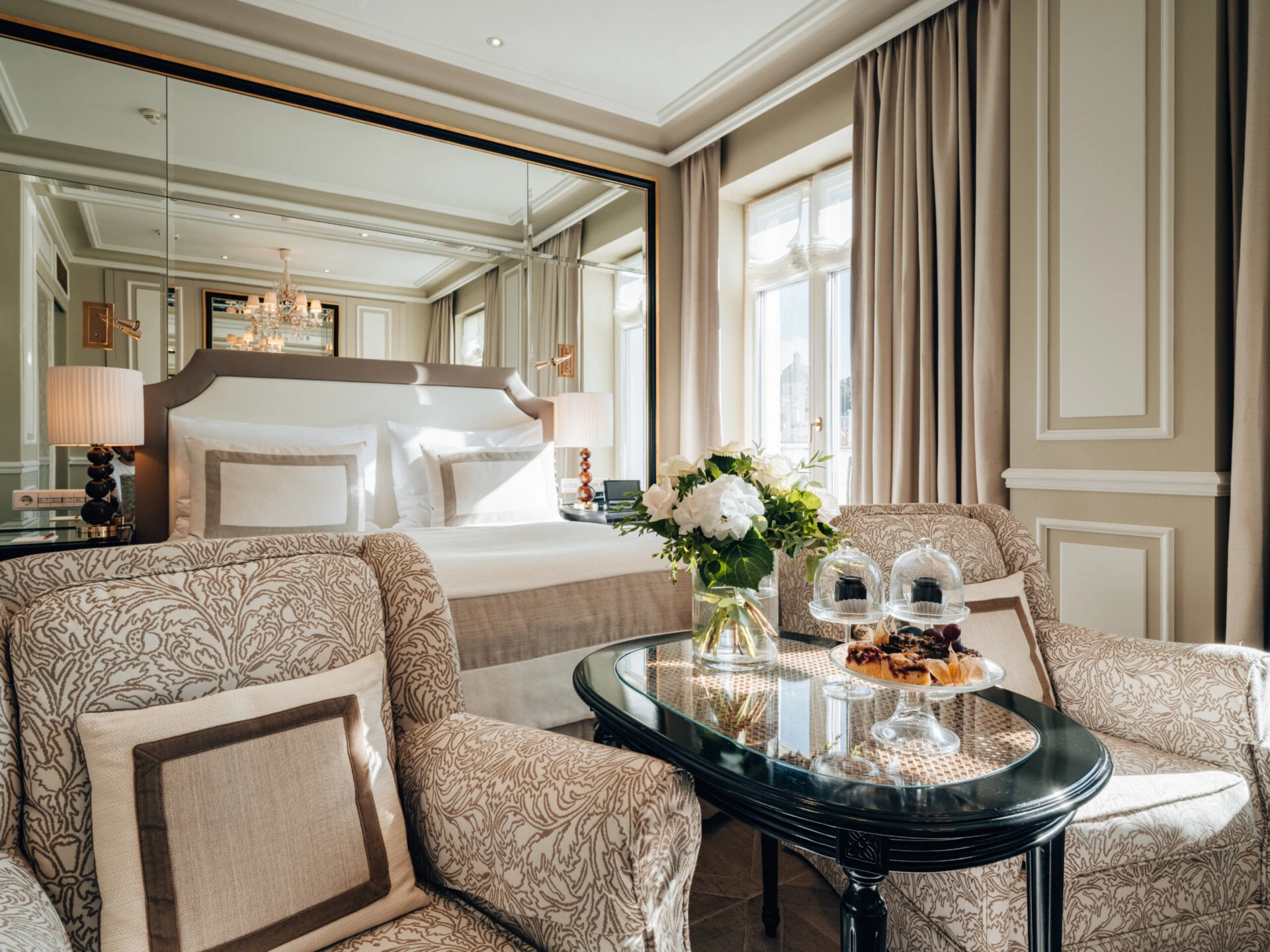Elegant deluxe room with a double bed and a cosy seating area.