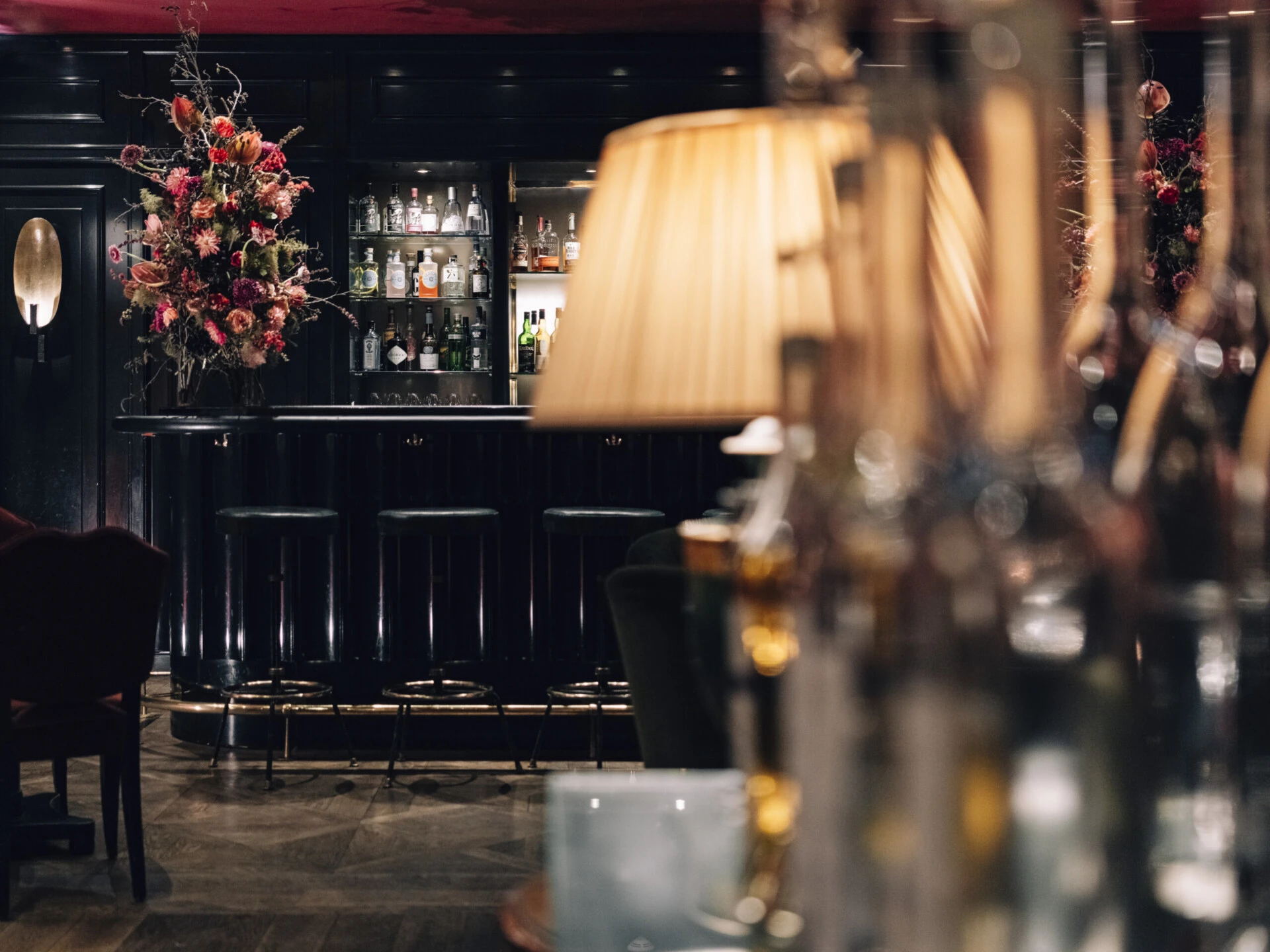 Atmospheric view of the bar with warm lighting and dark interiors.