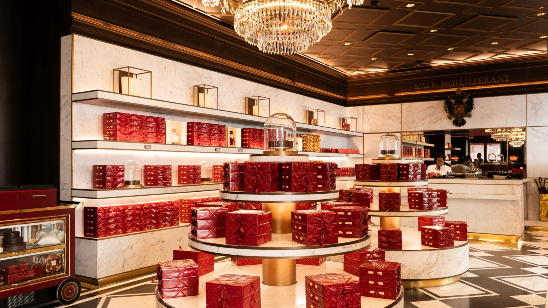 Elegant Sacher confectionery with marble displays and numerous red-packaged Original Sacher-Torte.
