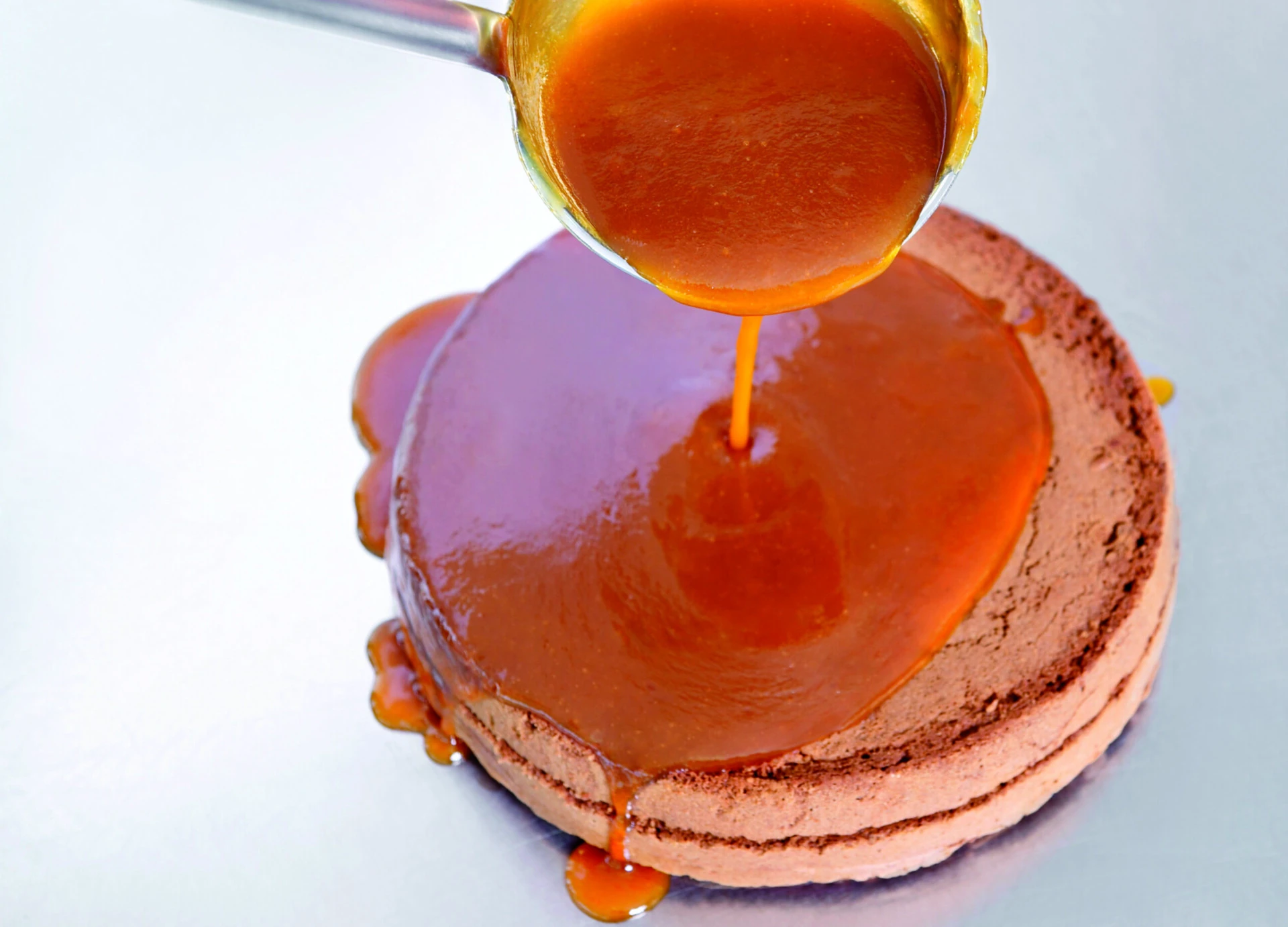 Apricot jam is poured over the cake base of the Original Sacher-Torte.