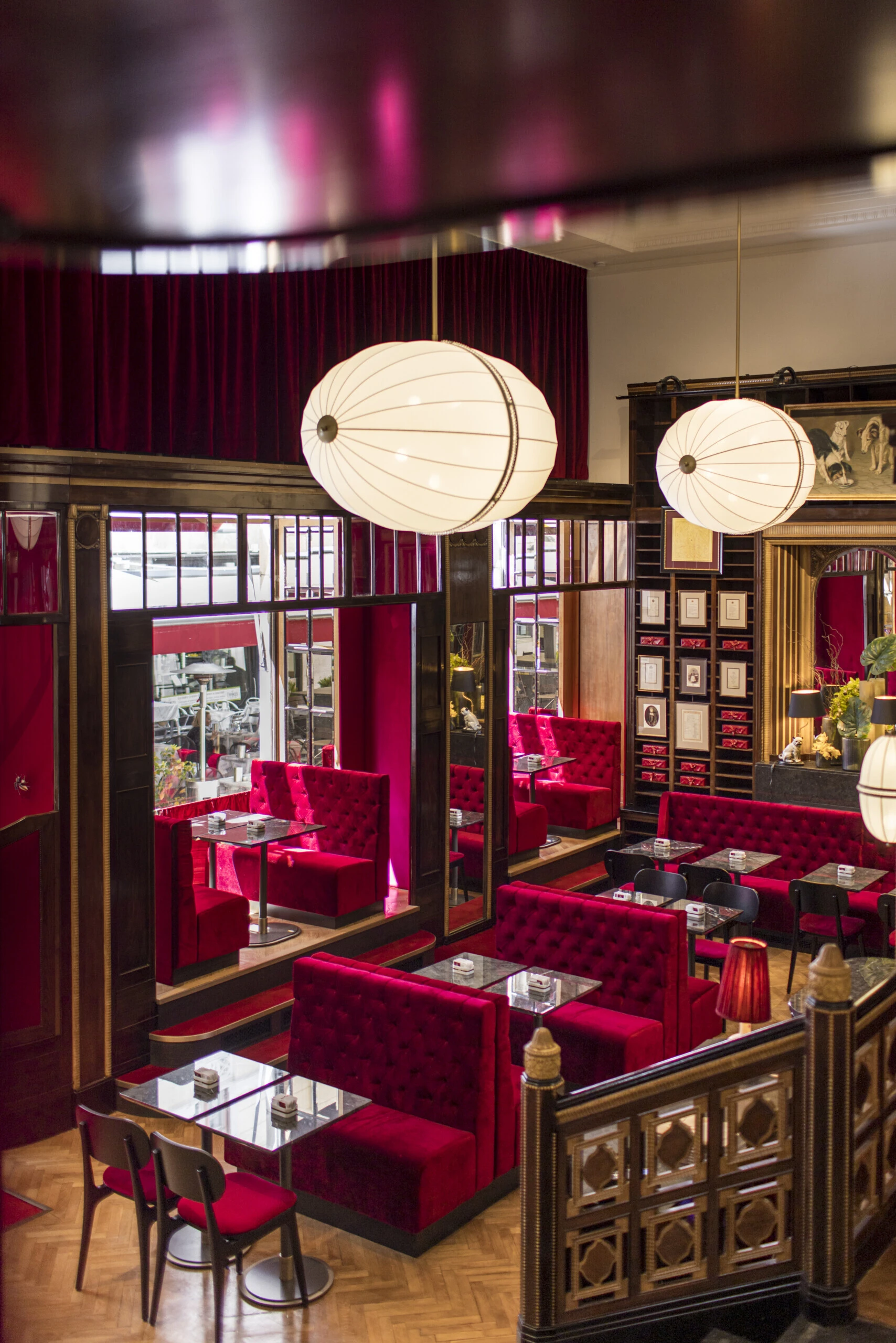 Elevated view of the Caffè Sacher Trieste dining area with red velvet seating.