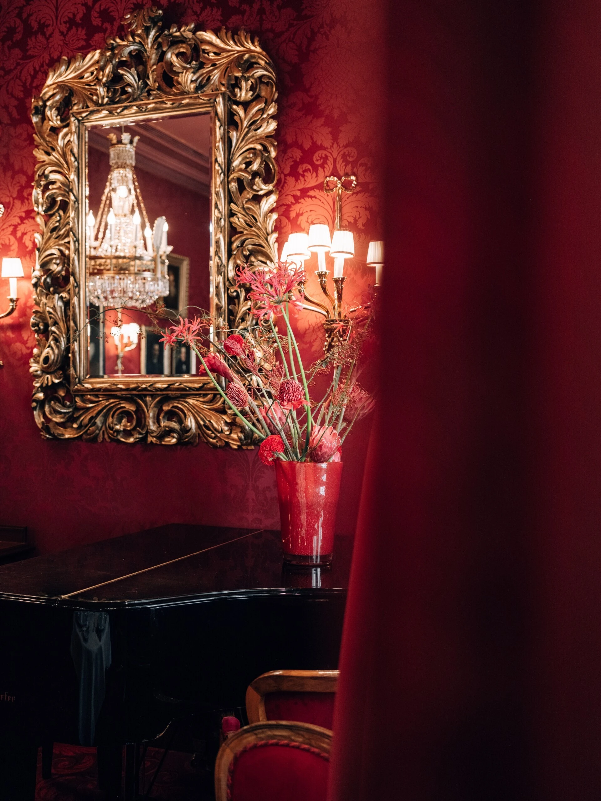 Festively set Restaurant Rote Bar at Hotel Sacher Vienna with piano.