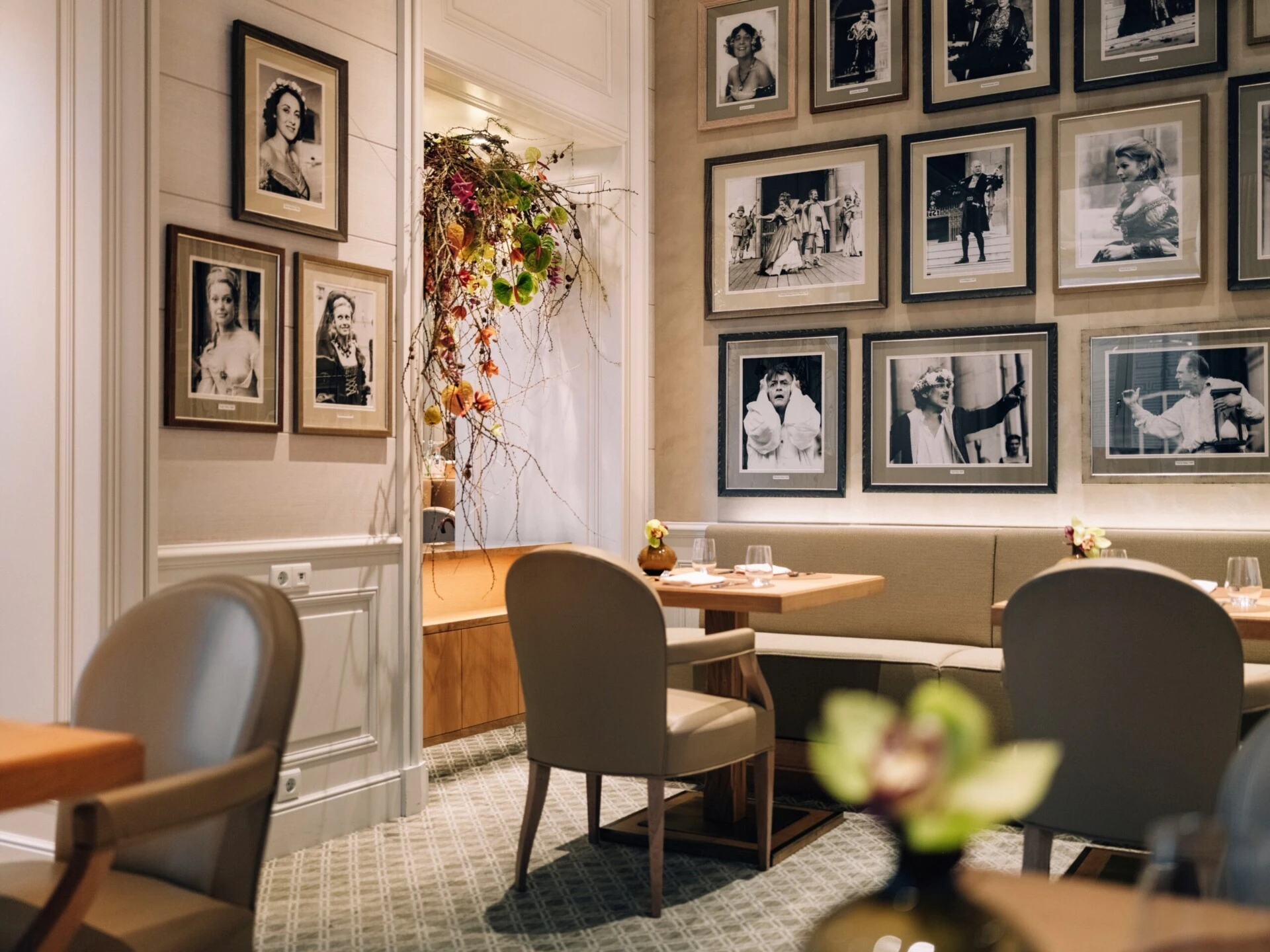 Elegant dining area with set tables and historic photographs.