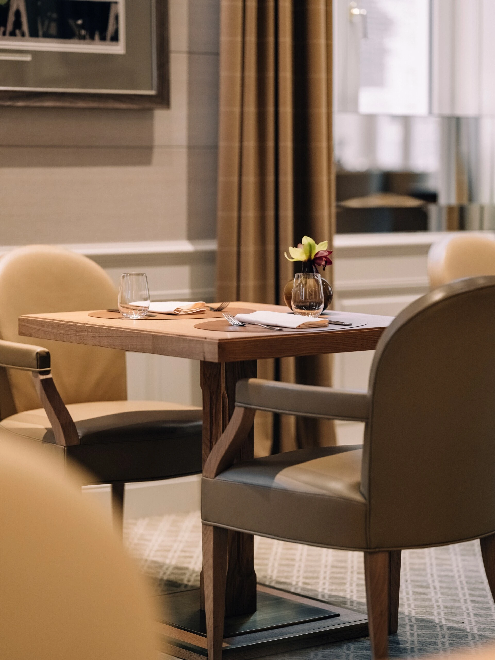 Gedeckter Holztisch mit Orchidee im Sacher Grill.