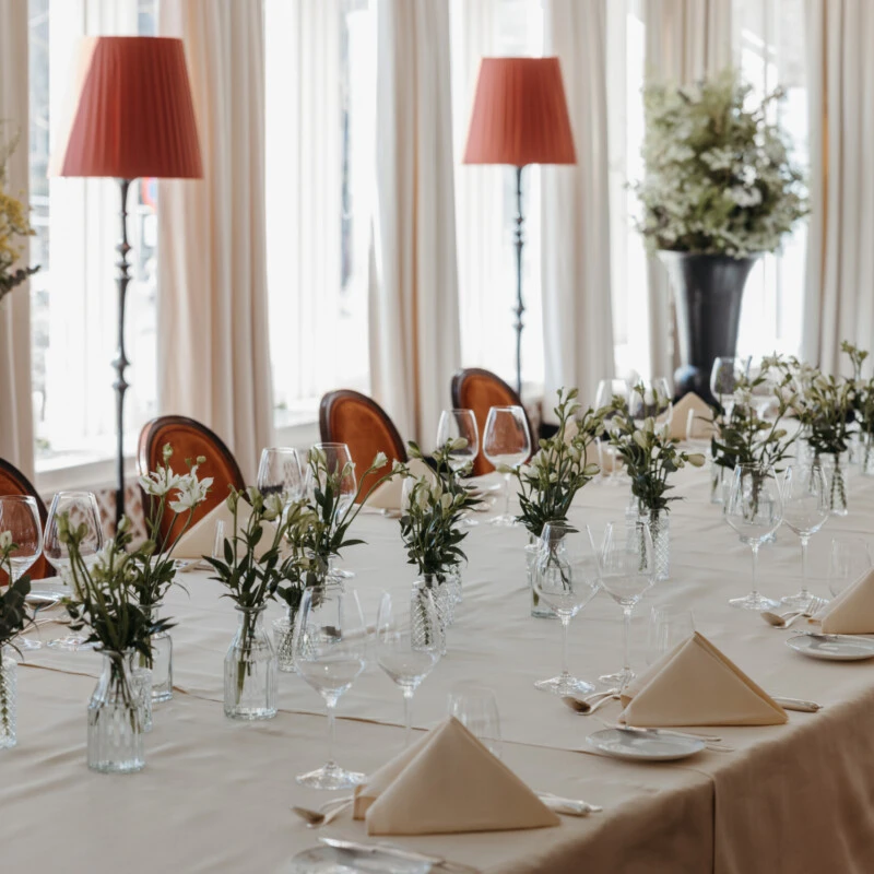 Elegantly set table with floral arrangements at an event venue at Hotel Sacher Salzburg.