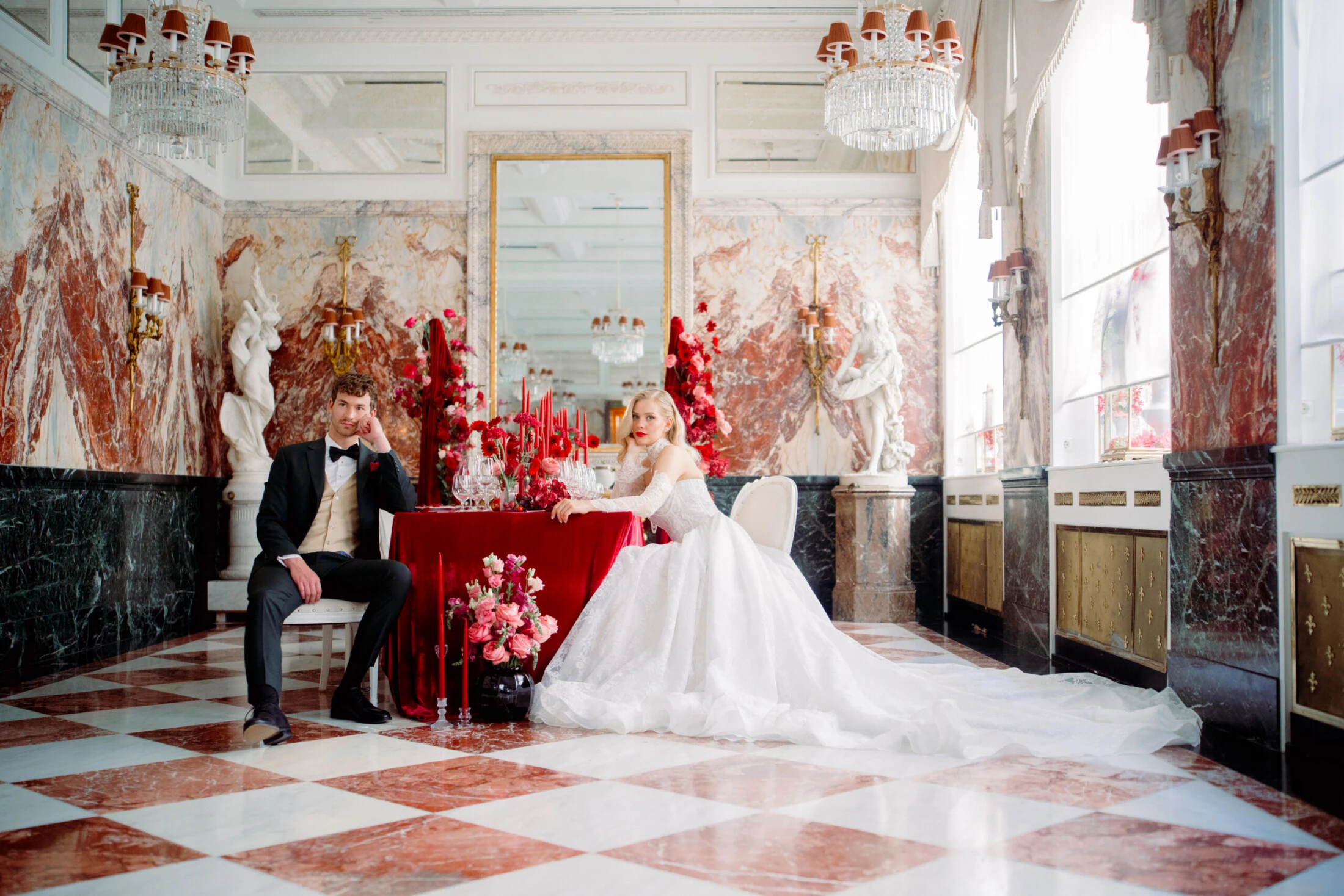 The bride and groom at a festively decorated wedding table in the Marble Hall of the Hotel Sacher Vienna.