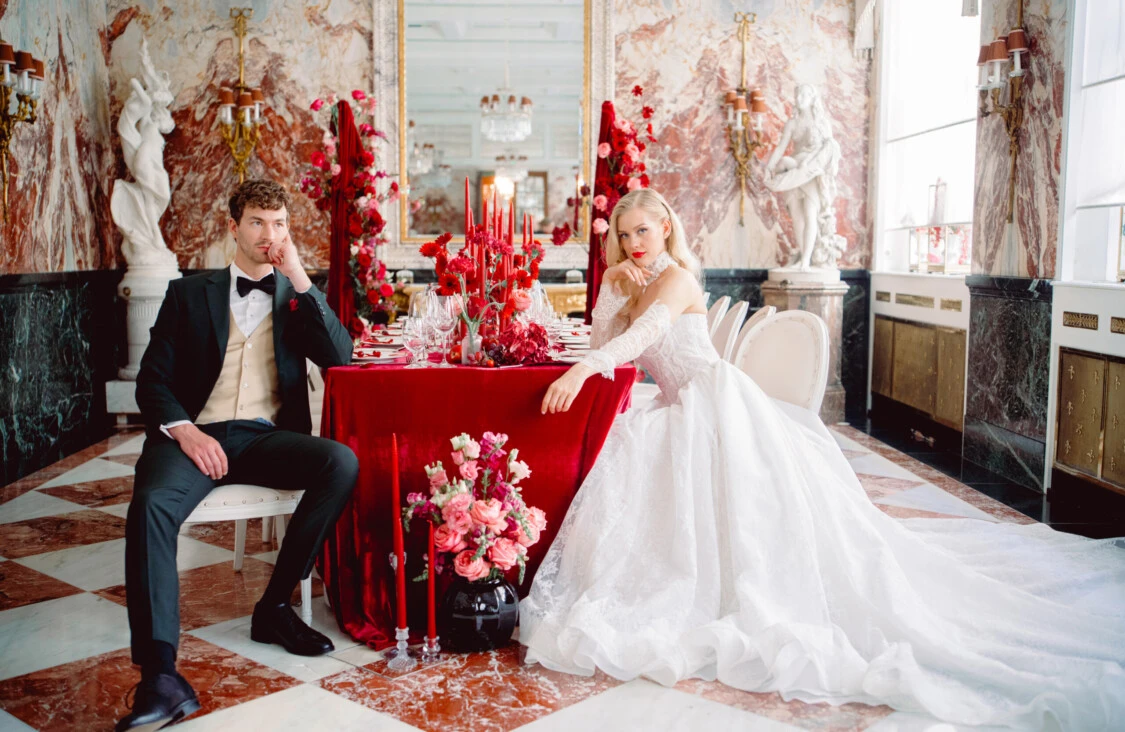 The bride and groom at a festively decorated wedding table in the Marble Hall of the Hotel Sacher Vienna.