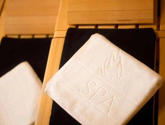 Impression-Sauna_559_422 A white towel embroidered with the word
