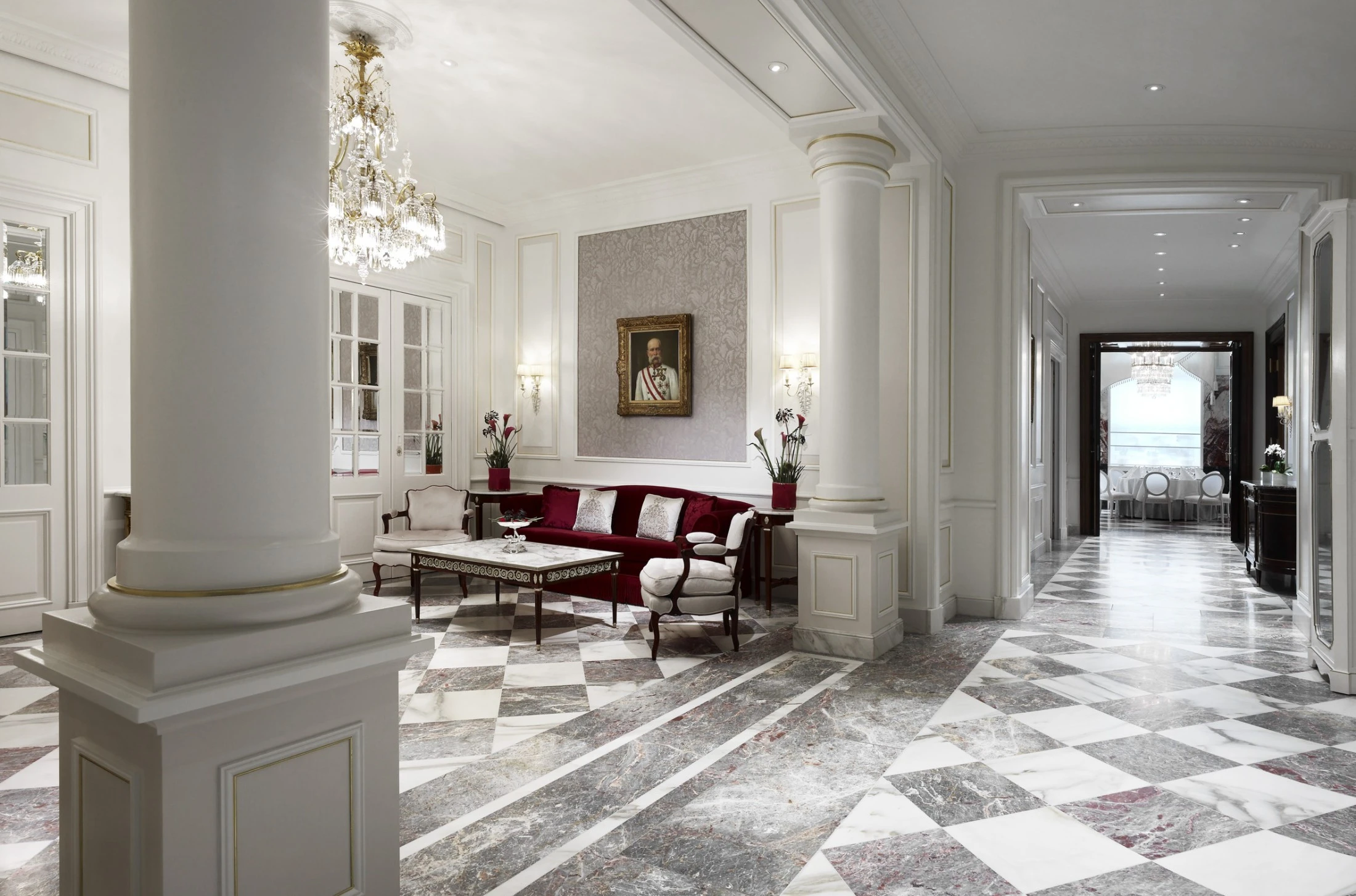 This is the Schönbrunner Loge at Hotel Sacher — a luxurious space featuring marble floors, ornate chandeliers, and elegant imperial-style decor.