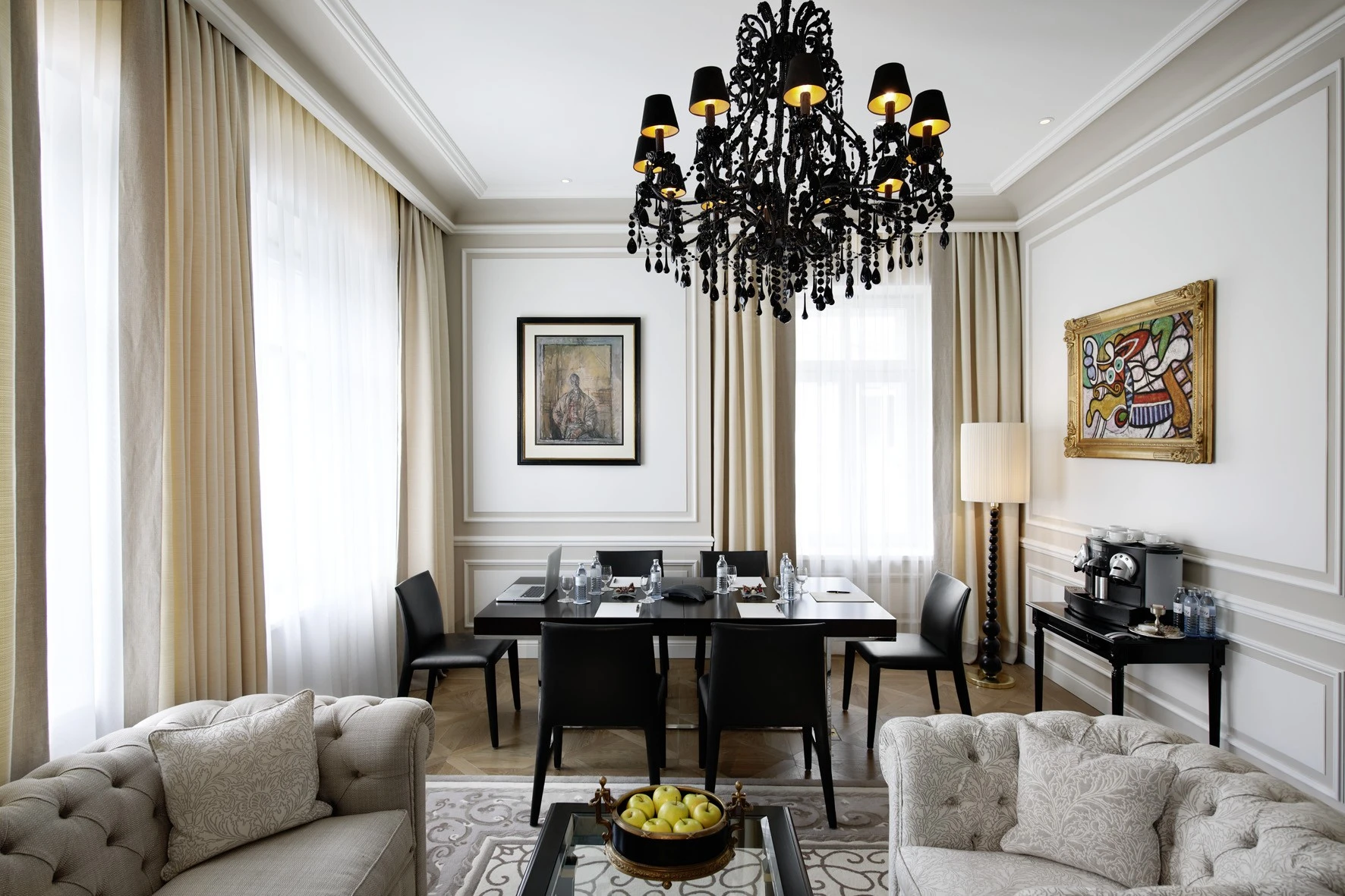 A stylish meeting room at Hotel Sacher Salzburg with a dramatic black chandelier, elegant furnishings, and soft natural light from large windows.
