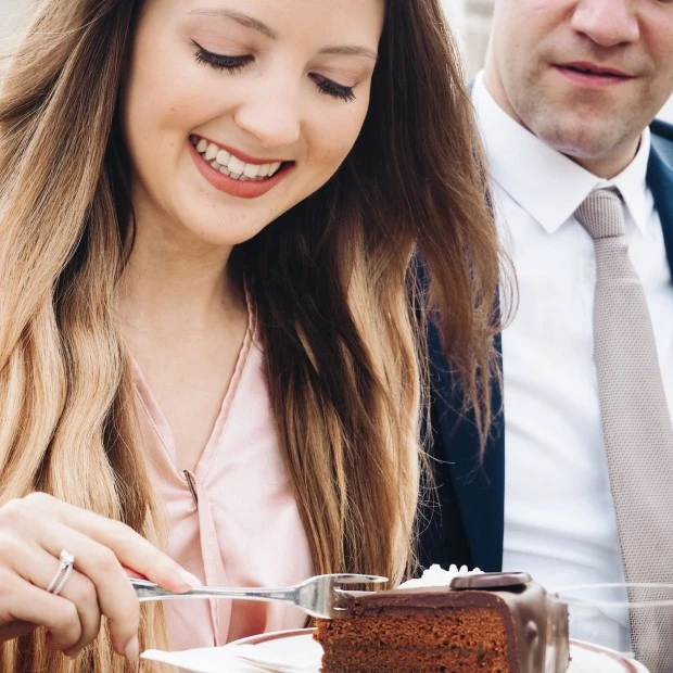 A couple enjoys a luxurious outdoor dining experience from a horse-drawn carriage in Vienna, indulging in champagne, savory bites, and slices of the Original Sacher-Torte, blending imperial charm with gourmet elegance in the heart of the city.