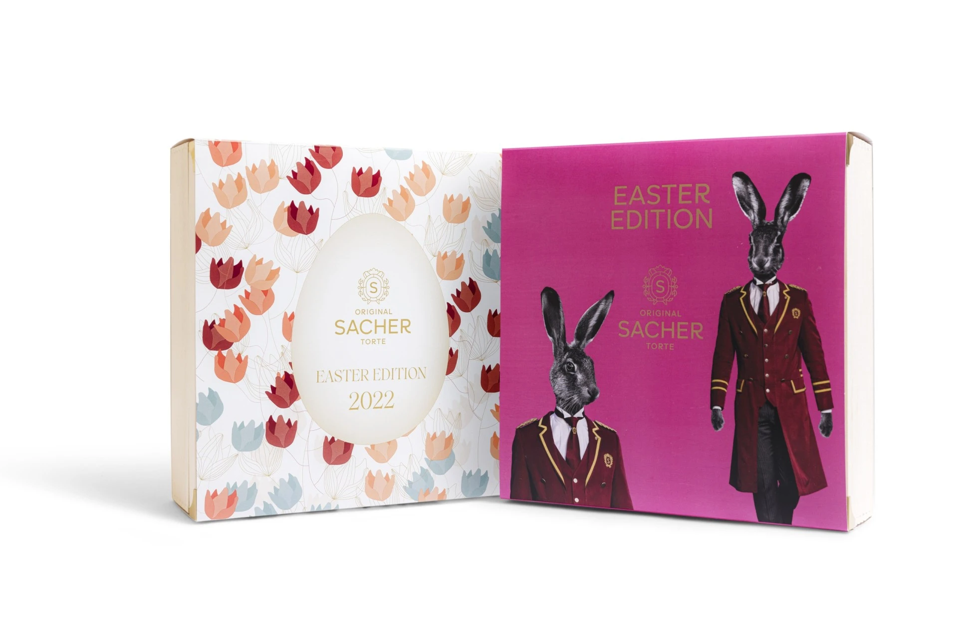 The 2022 Easter Edition of the Original Sacher-Torte, featuring two complementary box designs: one with a delicate floral pattern and golden egg motif, and the other with playful rabbits dressed in Hotel Sacher uniforms against a vibrant pink background.