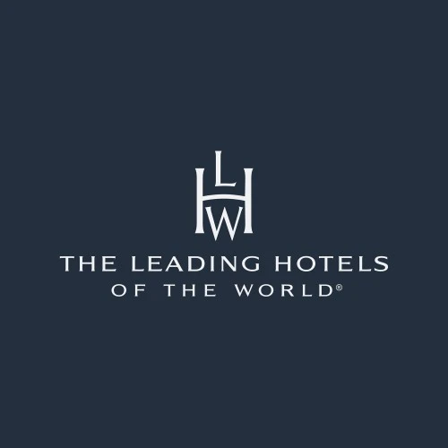 This image shows the elegant logo of “The Leading Hotels of the World,” featuring a stylized monogram with the letters L, H, and W above the brand name in clean, white capital letters on a dark background.