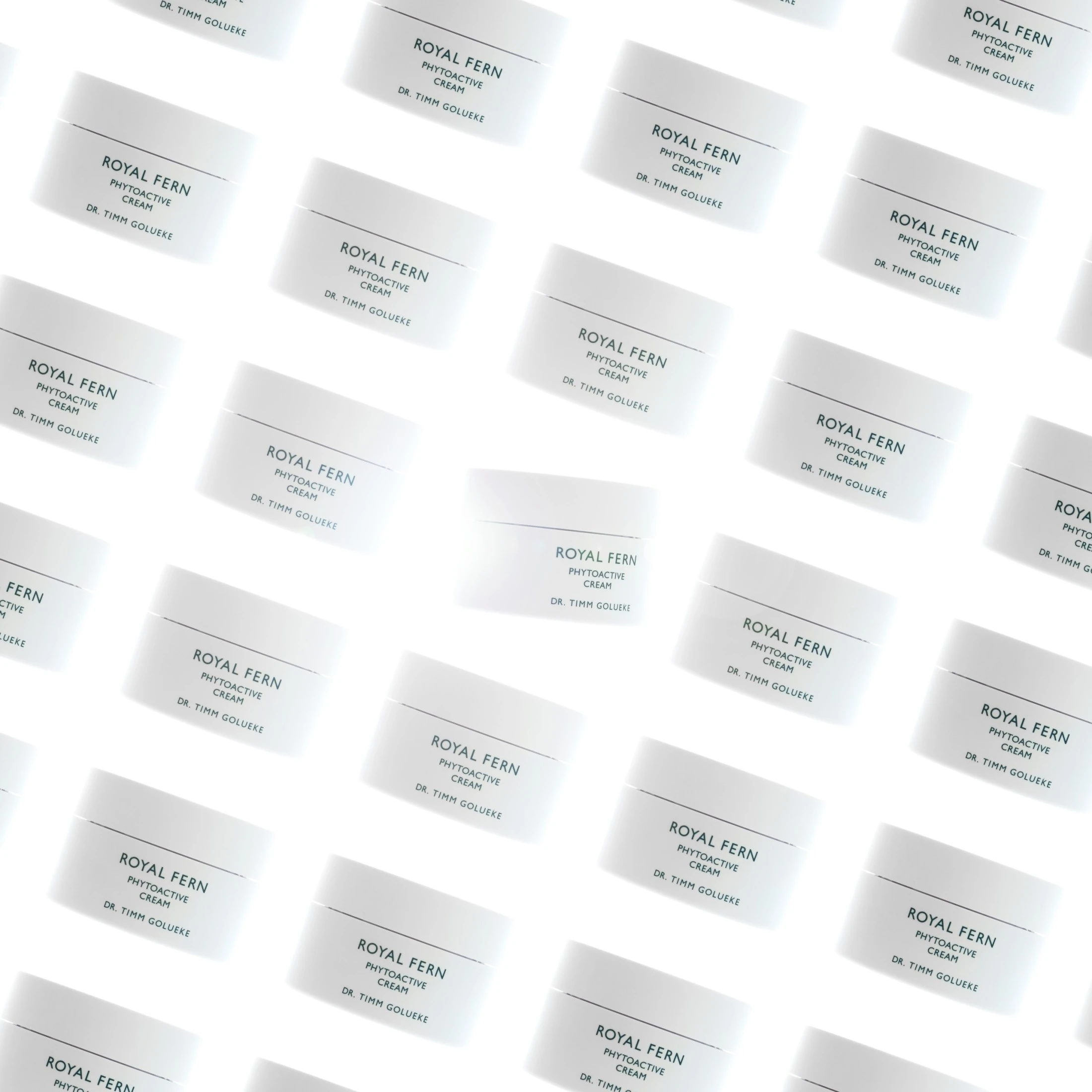 The image presents a visually striking pattern of multiple **Royal Fern Phytoactive Cream** jars by Dr. Timm Golueke, arranged in a diagonal, grid-like layout against a bright white background, showcasing the brand’s clean aesthetic and premium skincare identity.